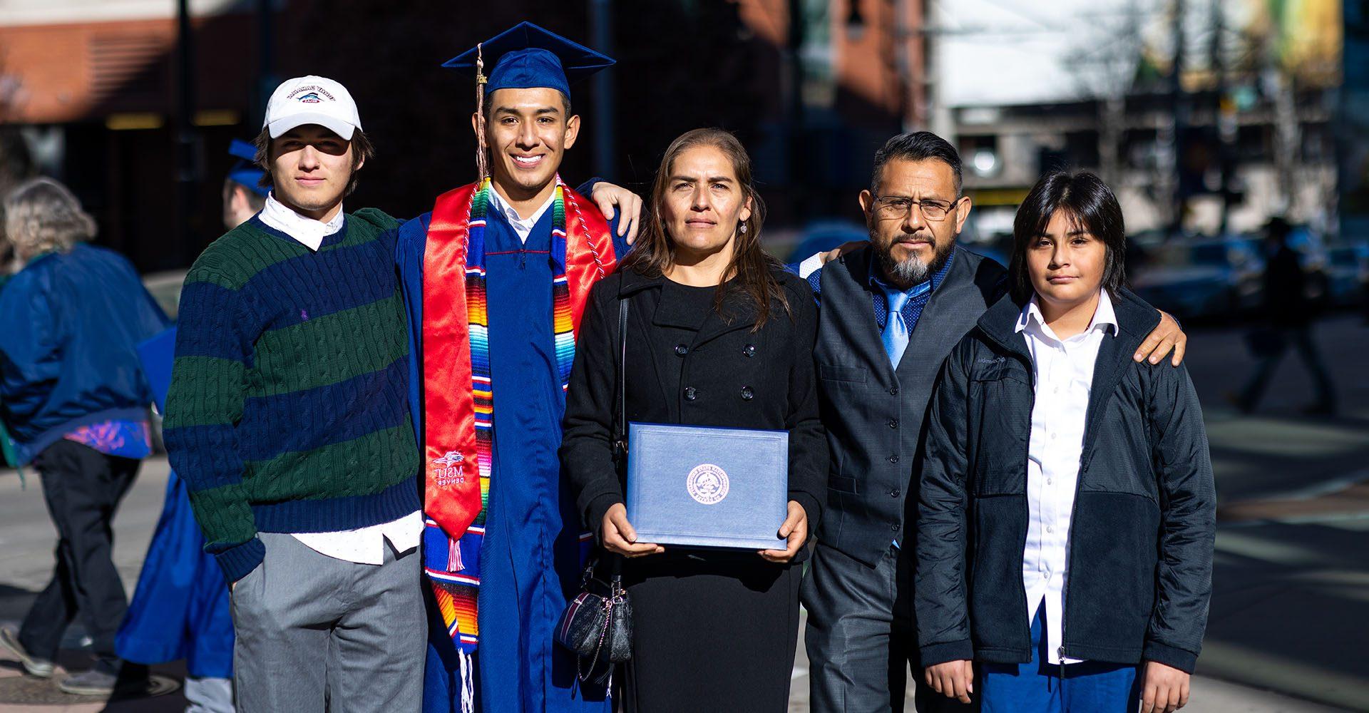 MSU Denver graduate poses with his family in Downtown Denver.